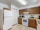 Bright kitchen with wood-look cabinets, white appliances, and a functional layout near the pantry at 31096 Inwood Cir, Brooksville, FL 34602
