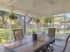 Covered, screened-in patio with dining area overlooking the green, landscaped backyard at 31096 Inwood Cir, Brooksville, FL 34602