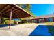 View of carports in front of brick homes with shade trees and well-maintained landscaping at 35140 Whispering Oaks Blvd, Dade City, FL 33523