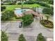 Image showcasing the community clubhouse, pool with seating, and lush surroundings from an aerial perspective at 3718 Beneraid St, Land O Lakes, FL 34638