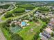 Aerial view of community amenities including a pool, tennis courts, and lush green landscaping near neighborhood homes at 3718 Beneraid St, Land O Lakes, FL 34638