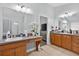 Well-lit bathroom with double vanity, tile floors, and neutral decor at 3718 Beneraid St, Land O Lakes, FL 34638