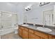Bathroom with a double sink vanity, tile floor, and a shower-tub combo, providing functionality and style at 3718 Beneraid St, Land O Lakes, FL 34638