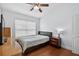 Well-lit bedroom featuring wood floors, a ceiling fan, and a large window, providing a cozy atmosphere at 3718 Beneraid St, Land O Lakes, FL 34638