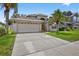 Beautiful home featuring a large driveway, two-car garage, manicured lawn, and mature landscaping at 3718 Beneraid St, Land O Lakes, FL 34638