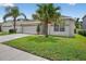 Charming single-story home with a well-manicured lawn, two-car garage, and palm trees at 3718 Beneraid St, Land O Lakes, FL 34638