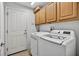 Functional laundry room with washer, dryer, cabinets, and clean, neutral tones at 3718 Beneraid St, Land O Lakes, FL 34638