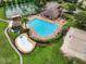 Aerial view of community pool and recreation area with lounge chairs, splash pad and beach volleyball court at 3718 Beneraid St, Land O Lakes, FL 34638