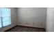 Simple bedroom featuring light wood floors, a window with blinds, and neutral-colored walls, offering a calming retreat at 401 Fern Cliff Ave, Temple Terrace, FL 33617