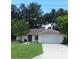 Charming one-story home with a well-manicured lawn, traditional details, and an attached garage at 401 Fern Cliff Ave, Temple Terrace, FL 33617