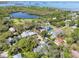 An aerial view shows this residential neighborhood surrounded by a lush green landscape at 408 Georgia Ave, Crystal Beach, FL 34681