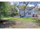 Spacious backyard with a two-story home, wooden deck, and large mature trees at 408 Georgia Ave, Crystal Beach, FL 34681
