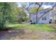Large green backyard features a two-story house, deck, and shady mature trees at 408 Georgia Ave, Crystal Beach, FL 34681
