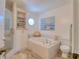 Bright bathroom featuring a soaking tub with a framed window and tiled surround at 408 Georgia Ave, Crystal Beach, FL 34681