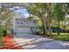 Charming two-story home with a large driveway, balcony, and mature trees at 408 Georgia Ave, Crystal Beach, FL 34681