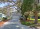 A two-story home with a charming balcony stands proudly framed by mature trees and lush landscaping at 408 Georgia Ave, Crystal Beach, FL 34681