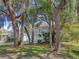 A two-story home with a charming balcony stands proudly framed by mature trees and lush landscaping at 408 Georgia Ave, Crystal Beach, FL 34681