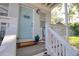 Close-up of a welcoming front porch area with a light blue door and coastal decor at 408 Georgia Ave, Crystal Beach, FL 34681