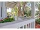 Close-up of a cozy front porch with views of the trees in the front yard at 408 Georgia Ave, Crystal Beach, FL 34681