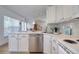 Well-lit kitchen features stainless appliances, stone countertops, and view to the dining area at 408 Georgia Ave, Crystal Beach, FL 34681