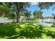 Backyard view with pool, artificial turf, and perimeter landscaping at 4114 W Neptune St, Tampa, FL 33629