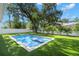 Backyard showcases a sparkling pool, lush landscaping, and an artificial lawn at 4114 W Neptune St, Tampa, FL 33629