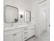 Modern bathroom featuring a double vanity with sleek mirrors and a walk-in shower with white tile and a curtain at 4114 W Neptune St, Tampa, FL 33629