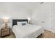Clean bedroom with white walls and hardwood floors with a comfortable bed and modern lamps on the nightstands at 4114 W Neptune St, Tampa, FL 33629