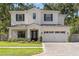 Beautiful two-story white home featuring black shutters, well-manicured lawn, and spacious two car garage at 4114 W Neptune St, Tampa, FL 33629