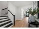 Bright foyer featuring hardwood floors, white walls, and a staircase with black and white accents at 4114 W Neptune St, Tampa, FL 33629