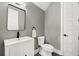 Stylish half bathroom with patterned wallpaper, a modern mirror, and a sleek vanity sink and faucet fixture at 4114 W Neptune St, Tampa, FL 33629