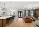 Spacious living room with hardwood floors, leather sofa, chandelier, and open to the kitchen at 4114 W Neptune St, Tampa, FL 33629