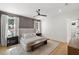 This main bedroom features a textured accent wall, wooden floors, bench, and soft, natural light at 4114 W Neptune St, Tampa, FL 33629