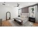This main bedroom features a neutral palette, wooden floors, bench, and soft, natural light at 4114 W Neptune St, Tampa, FL 33629
