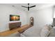 This main bedroom features a decorative sunset painting, wooden floors, and a full-length mirror at 4114 W Neptune St, Tampa, FL 33629