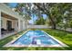 Beautiful in-ground pool with a tile and plaster finish, surrounded by lush green lawn and mature trees at 4114 W Neptune St, Tampa, FL 33629