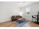 Cozy sitting room with a comfortable leather couch, a window with shutters, and hardwood flooring at 4114 W Neptune St, Tampa, FL 33629