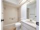 Neutral-toned bathroom featuring a tiled tub-shower, sink and vanity with a large mirror, and bright lighting at 498 Lakeview Dr # 45, Palm Harbor, FL 34683