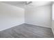 Bright bedroom with gray wood-look flooring, white walls, a ceiling fan, and natural light from a window at 498 Lakeview Dr # 45, Palm Harbor, FL 34683