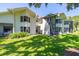 Exterior of the home with lawn, mature landscaping, white siding, and dark trim at 498 Lakeview Dr # 45, Palm Harbor, FL 34683