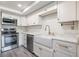 Modern kitchen featuring stainless steel appliances, white cabinets, and a stylish farmhouse sink at 498 Lakeview Dr # 45, Palm Harbor, FL 34683