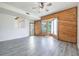 Bright living room featuring hardwood floors, a wood accent wall, and a ceiling fan at 498 Lakeview Dr # 45, Palm Harbor, FL 34683