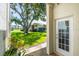 View of the condo community from the covered back patio featuring green space, mature trees, and building exteriors at 498 Lakeview Dr # 45, Palm Harbor, FL 34683