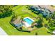 Aerial view of a community pool featuring a bath house, lounging chairs, and meticulously maintained landscaping at 498 Lakeview Dr # 45, Palm Harbor, FL 34683