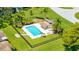 Aerial view of a community pool featuring a bath house, lounging chairs, and meticulously maintained landscaping at 498 Lakeview Dr # 45, Palm Harbor, FL 34683