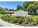 Community sign for the Townhomes of Westlake Village with colorful flowering landscaping in front at 498 Lakeview Dr # 45, Palm Harbor, FL 34683