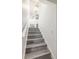 Staircase with light wood-look steps and white risers, leading to the upper level at 498 Lakeview Dr # 45, Palm Harbor, FL 34683