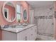 Elegant bathroom featuring a double vanity, granite countertop, and a modern tiled shower with pebble flooring accents at 505 Broxburn Ave, Temple Terrace, FL 33617
