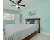 Bright bedroom with a ceiling fan, a window, and striped bedding at 505 Broxburn Ave, Temple Terrace, FL 33617
