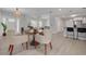 Open-concept dining area with modern lighting, wood-look floors, and a view of the kitchen at 505 Broxburn Ave, Temple Terrace, FL 33617